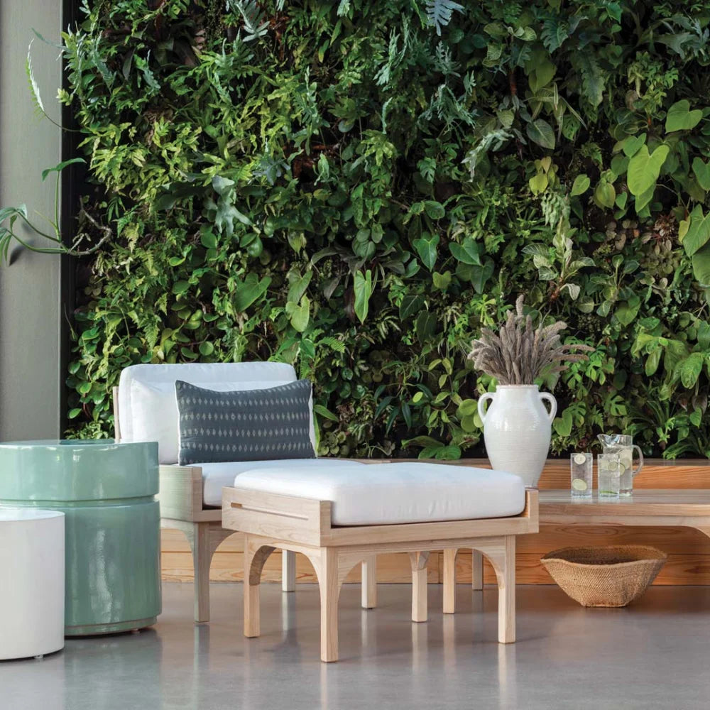 Outdoor seating area with a green wall and decorative elements