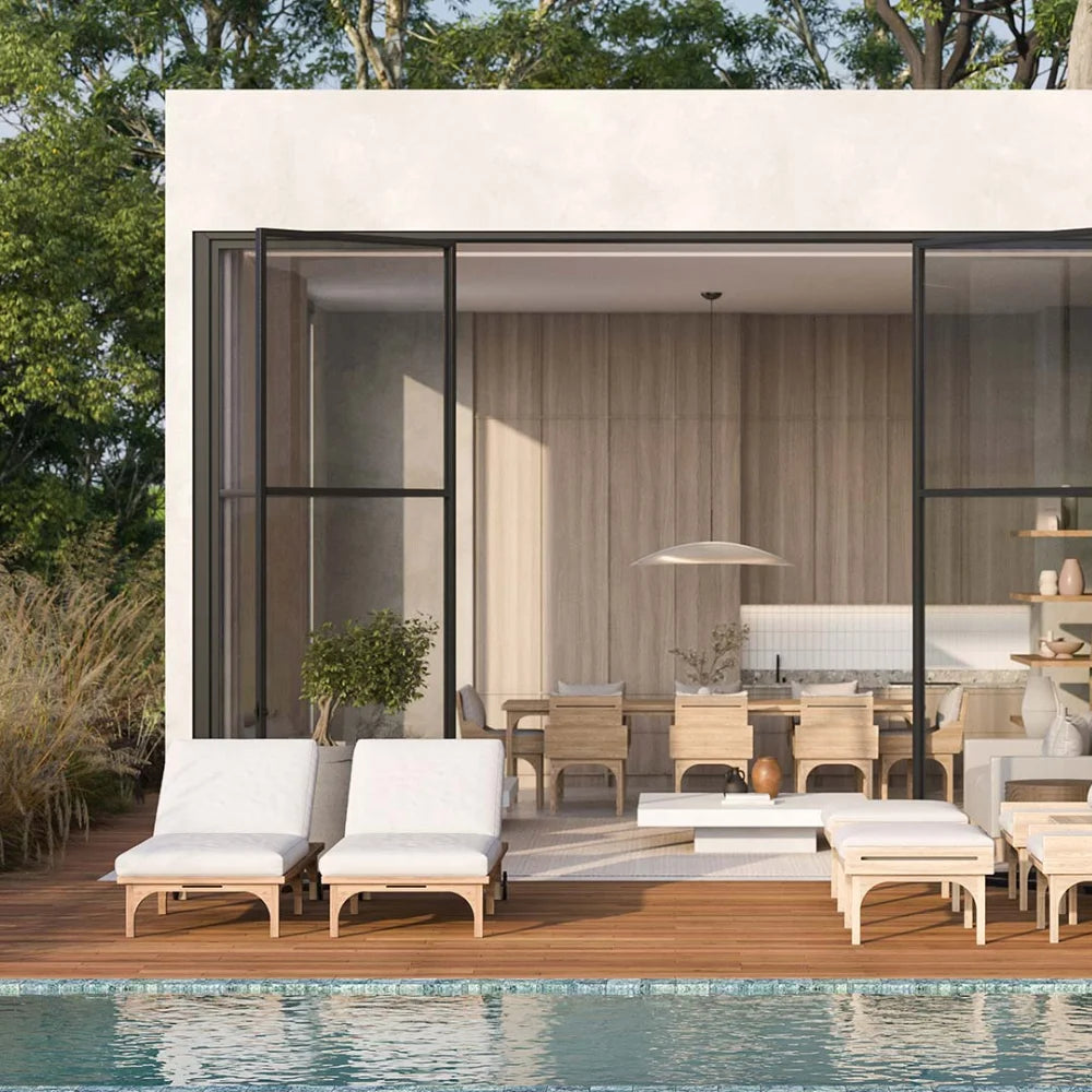 Modern outdoor patio area with lounge chairs, dining table, and kitchen overlooking a pool.