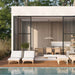 Modern outdoor patio area with lounge chairs, dining table, and kitchen overlooking a pool.