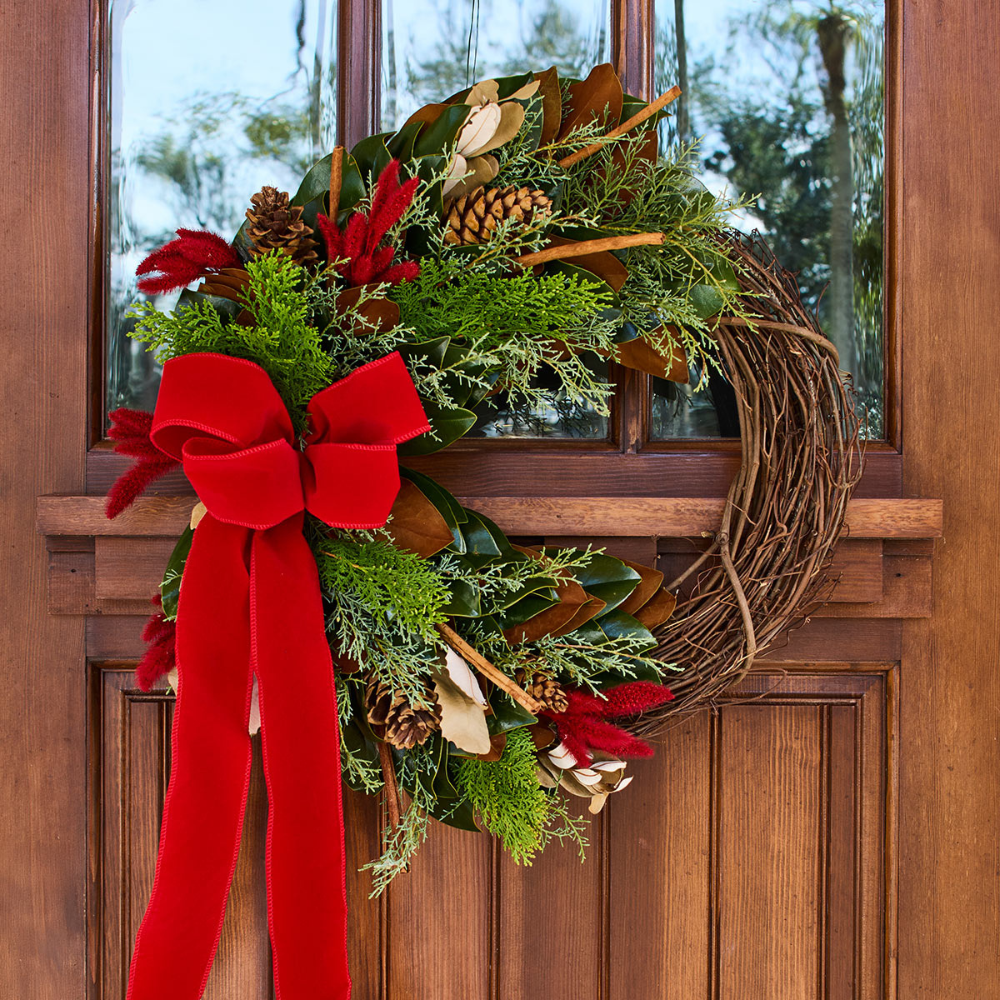 Christmas wreath with red bow on a wooden door