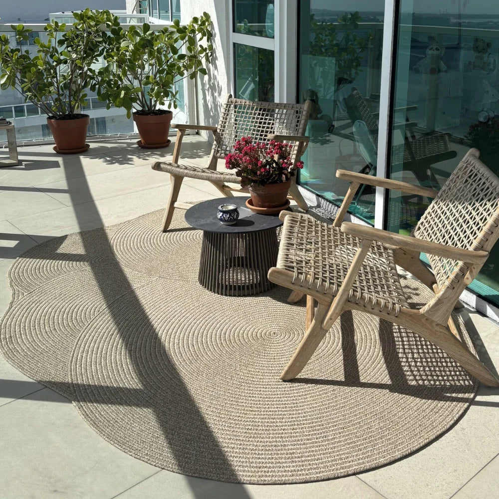 outdoor rug in brown woven material, placed under table and chairs for patio setting