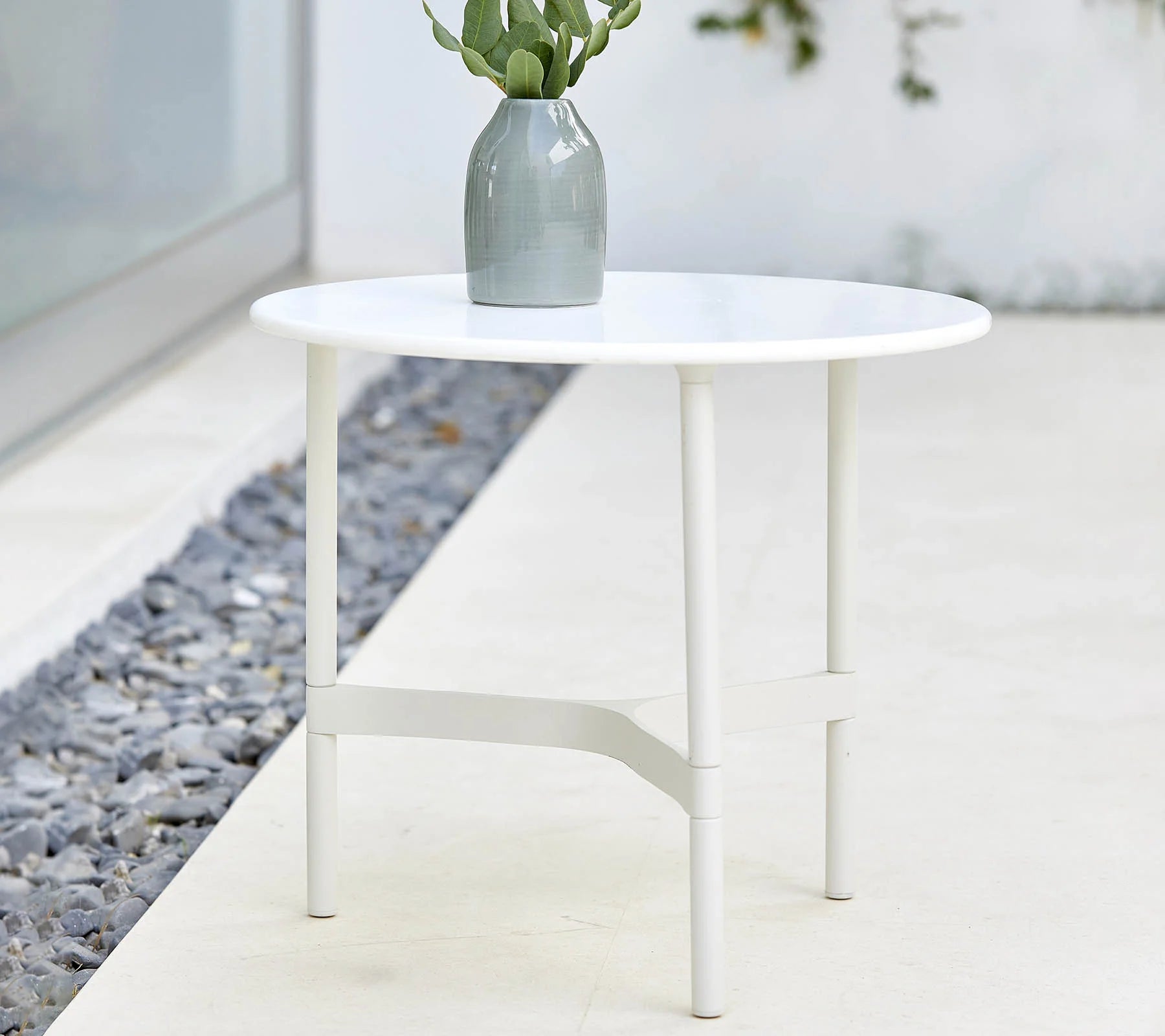  Boxhill's Twist white outdoor round coffee table with plants in a grey vase on it