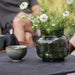 Boxhill's Twist grey rectangular outdoor coffee table with flowers in a green vase and green cup on it