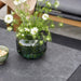 Boxhill's Twist dark grey rectangular outdoor coffee table with flowers in a green vase and cup with peanuts on top of it