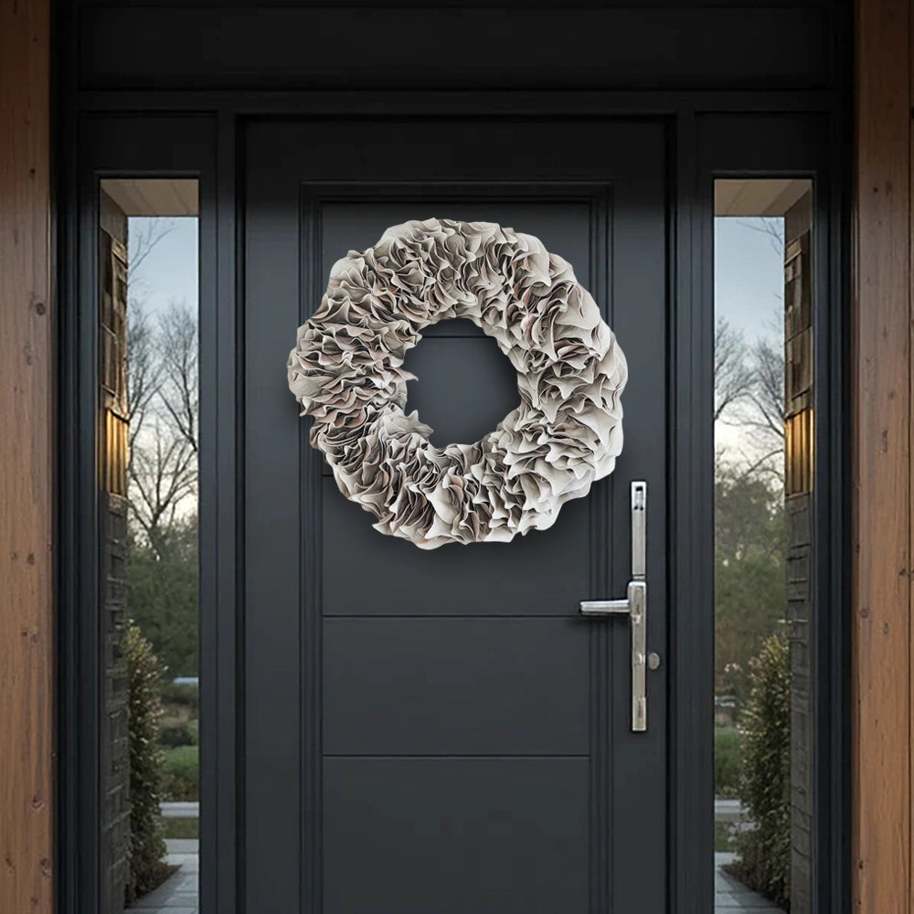 White ruffled lacquer wreath on a dark modern front door with glass side panels and wood accents.