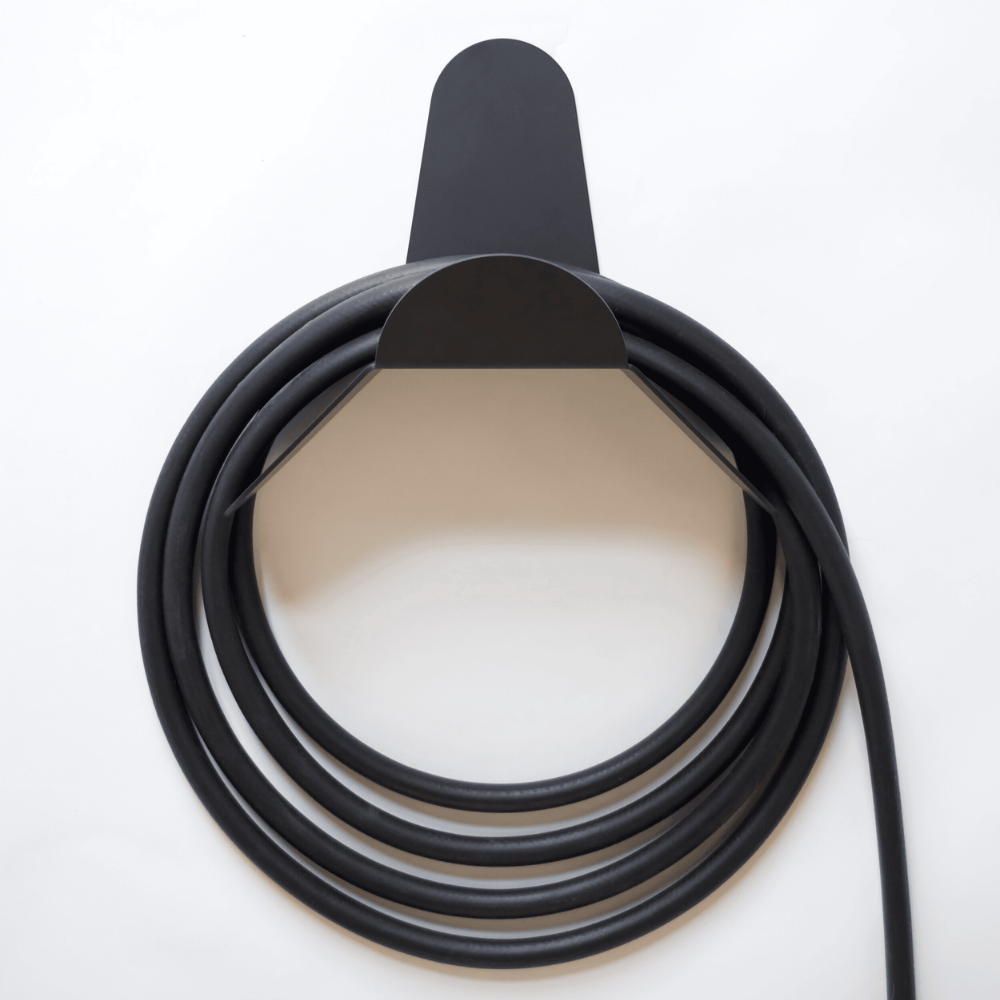 Coiled black cable with a metallic connector on a white background