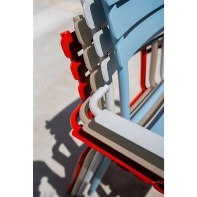 A close-up view of a vibrant stack of colorful outdoor chairs arranged neatly, showcasing various hues and designs.