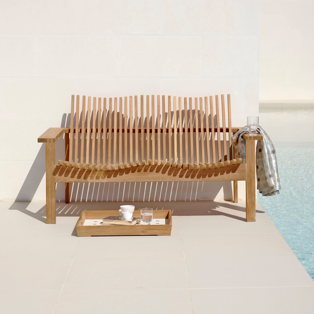 Boxhill's Amaze 2-Seater Teak Sofa lifestyle image without cushion beside the pool