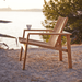 Boxhill's Amaze Stackable Lounge Teak Chair lifestyle image at the beach side with tea cup on the armrest