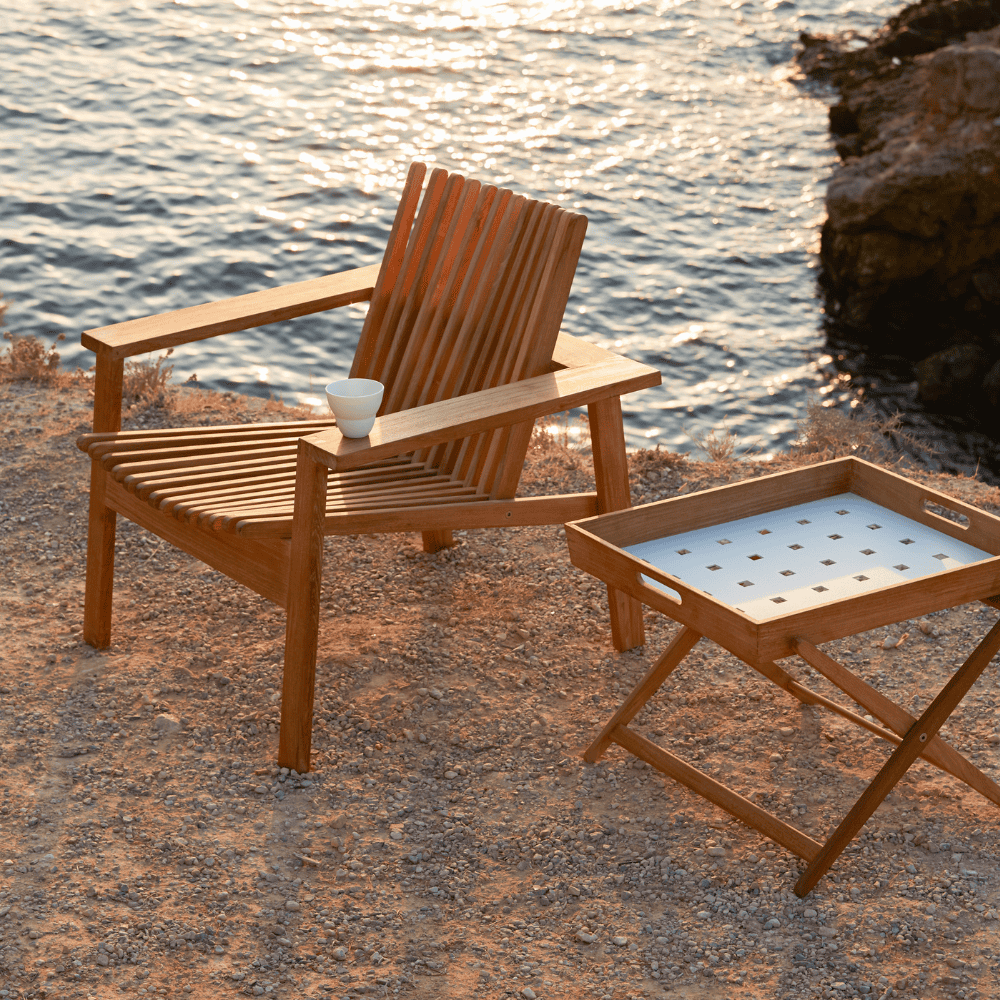 Boxhill's Amaze Stackable Lounge Teak Chair lifestyle image at the beach side