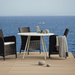 Boxhill's Area Outdoor Aluminum Dining Table White Lifestyle image on wooden platform at the sea front 