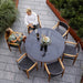 Boxhill's Aspect Teak Round Dining Table Clear Glass | Smokey Black lifestyle image with dining chairs and 2 people sitting down