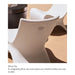 A close-up of a white molded in-pool lounge chair with an integrated headrest pillow clip, shown in a styled interior setting with a tan floor and a dark cylindrical table partially visible. Text below reads 'Pillow Clip' and describes the pillow clip cavity.
