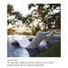 Two modern white curved outdoor lounge chairs placed in a pool in a landscaped backyard with trees, grass, and a glass railing. Text below reads 'Luxury Finish' with descriptive copy about the sleek finish and hidden headrest clip.