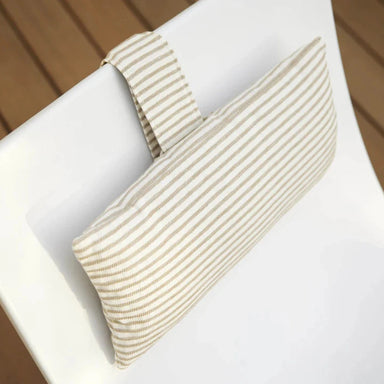 A rectangular headrest pillow with beige and white stripes on a white in-pool chair on a wooden deck.