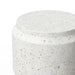 Close-up of a white speckled outdoor concrete round stool-end table against white background