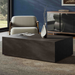 Modern living room with gray armchair, rectangular dark concrete coffee table holding a vase and book, blue wall, and wooden cabinet