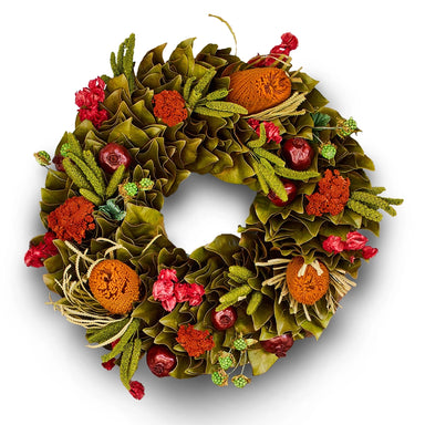 Handcrafted festive spring wreath with  green, red and orange natural texture accents on a white background.