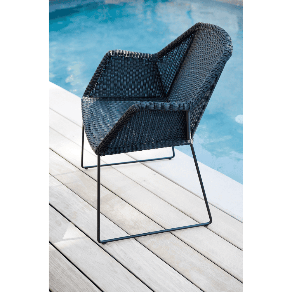 Boxhill's Breeze Dining Weave Chair Black lifestyle image beside the pool