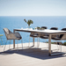 Boxhill's Breeze Dining Weave Chair White Grey lifestyle image with dining table at the seafront