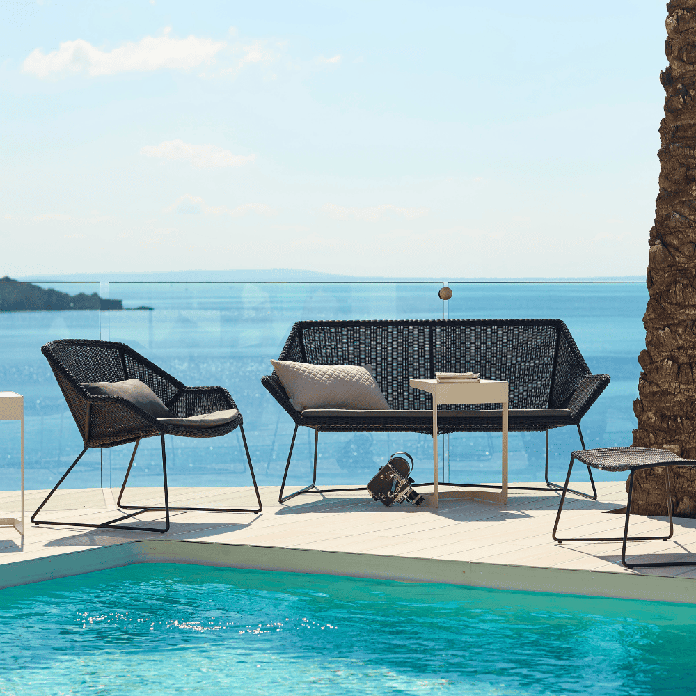 Boxhill's Breeze Outdoor Lounge Chair Black lifestyle image with Breeze 2-Seater Sofa beside the pool