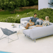 Boxhill's Breeze Outdoor Lounge Chair Light Grey lifestyle image with outdoor sofa in the garden with 2 people sitting down