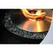 close up view of a stainless steel fire pit burner with flame over a fire glass