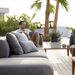 Boxhill's Capture Outdoor Pouf lifestyle image with Capture Module Sofa and Capture Coffee Table with a man sitting down