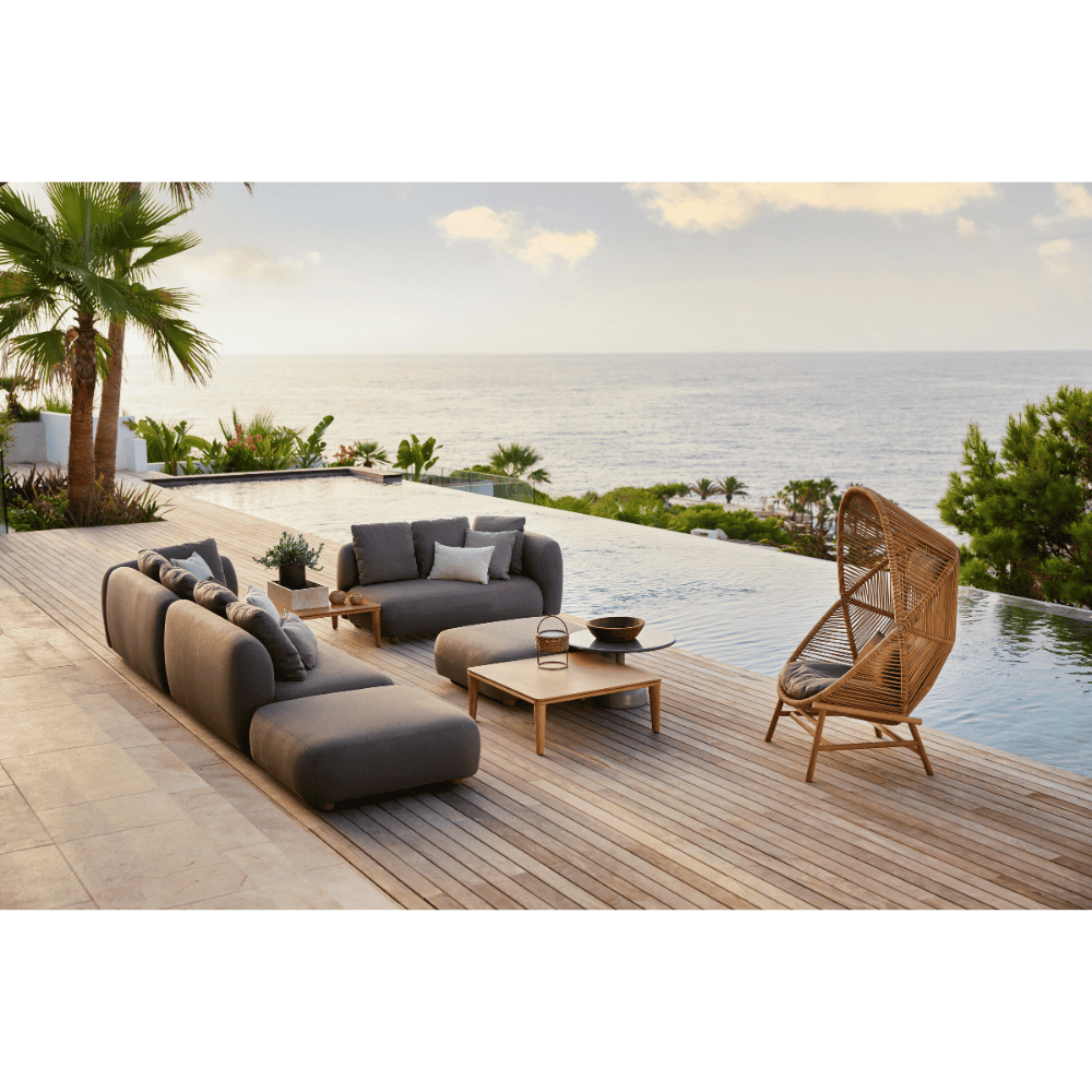 Boxhill's Capture Outdoor Corner Sofa w/ Coffee Table & Chaise lifestyle image on wooden platform beside the pool