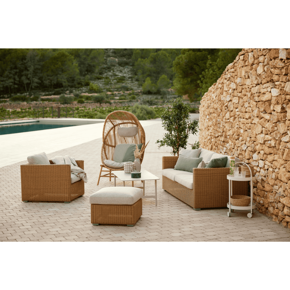 Boxhill's Chester 3-Seater Coastal Sofa Natural with Chester Footstool Weave Coffee Table and Chester Lounge Weave Coastal Chair lifestyle image near poolside
