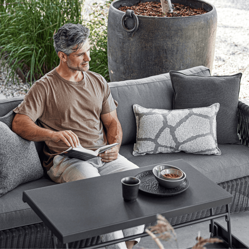 Boxhill's Chill-Out Coffee Table, Dual Heights Black lifestyle image with a man sitting down