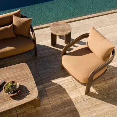 Brown modern outdoor lounge chair paired with a matching sofa, textured coffee table, and side table, placed beside the pool