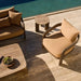 Modern brown lounge chair with matching sofa, gray round outdoor side table, and rectangular coffee table by pool