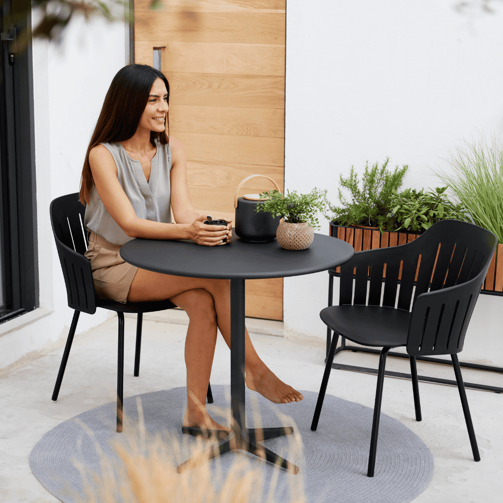 Boxhill's Choice Outdoor Dining Chair Warm Galvanized Steel Legs lifestyle image with a woman sitting down