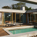Modern outdoor patio with two metal framed outdoor chaise loungers with beige cushions on a wooden deck beside the pool