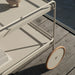 Close up view of beige outdoor serving cart with wheels on a wooden deck patio