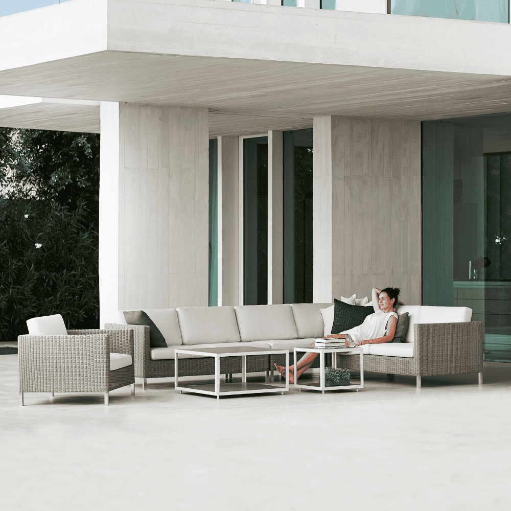 Boxhill's Connect Module Sofa lifestyle image with other module sofa, Connect Lounge Chair and a woman sitting down at patio