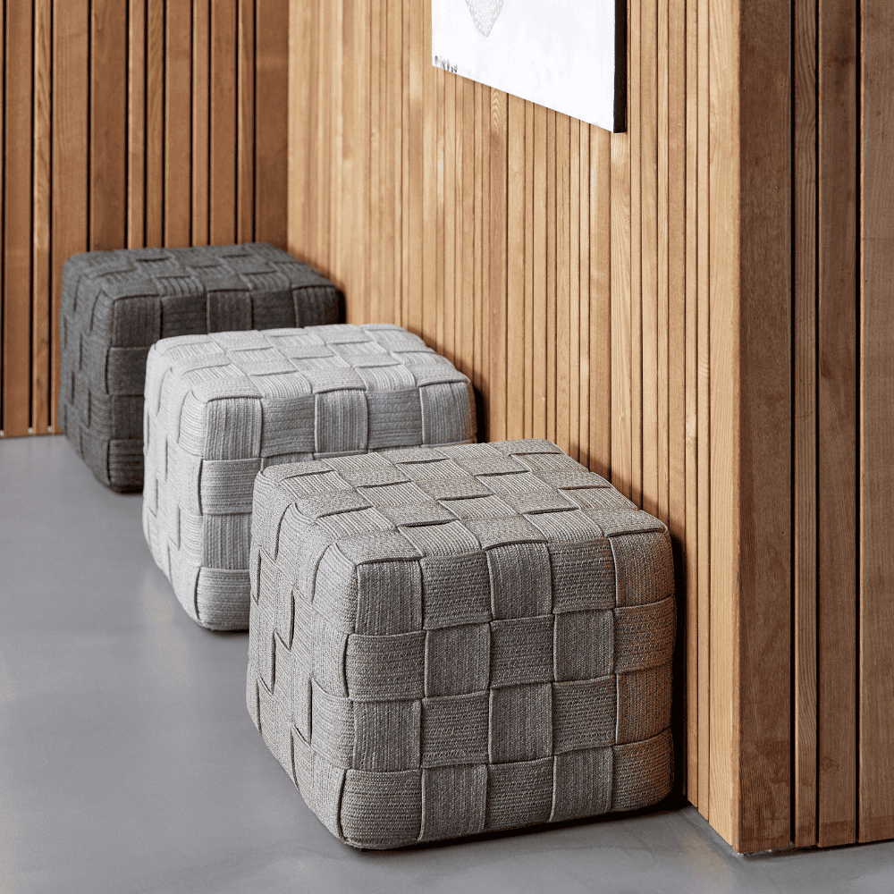Boxhill's Cube Outdoor Footstool Dark Grey, Light Grey and Taupe lifestyle image beside wooden wall