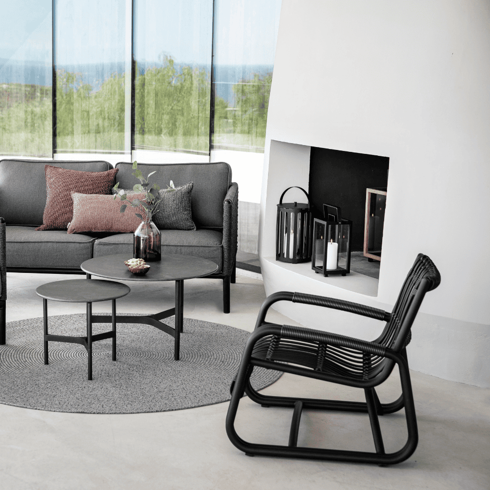 Boxhill's Curve Lounge Weave Outdoor Chair Graphite lifestyle image with 2 round table and 2-seater sofa