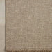 Close-up of a woven natural fiber outdoor rug in a warm beige color, showing the detailed texture and fringe along the bottom edge.