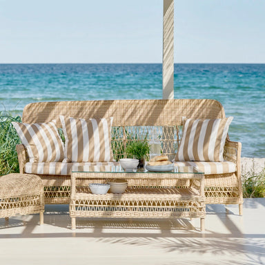 Natural wicker outdoor 3-seater sofa with striped beige and white cushions and matching coffee table.