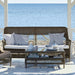 Grey wicker outdoor 3-seater sofa with white and blue striped cushions and matching coffee table.
