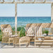 Natural wicker outdoor woven stool with matching armchair, 3-seater sofa and coffee table featuring striped cushions.