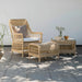 Natural wicker outdoor woven stool with matching armchair and side table featuring white cushions.
