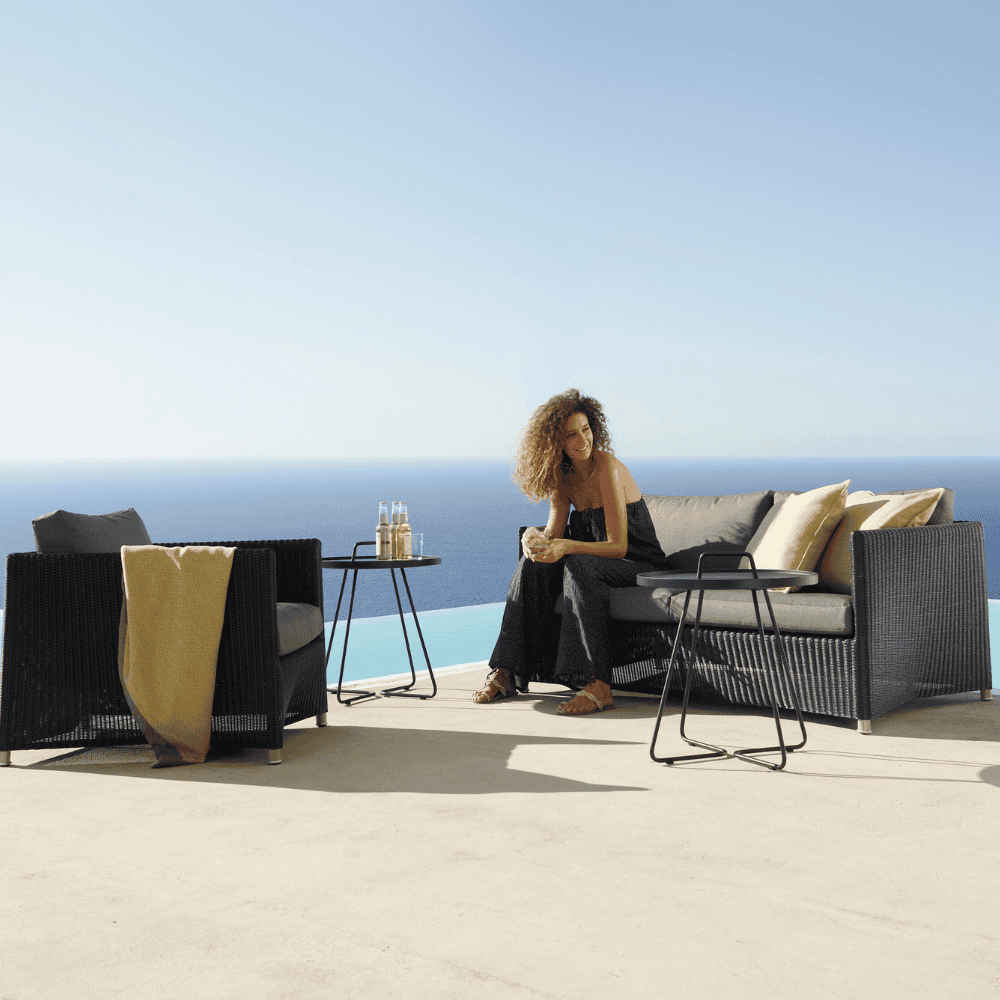 Boxhill's Diamond Weave Lounge Chair lifestyle image with Diamond 2-Seater Weave Sofa and a woman sitting down beside the pool