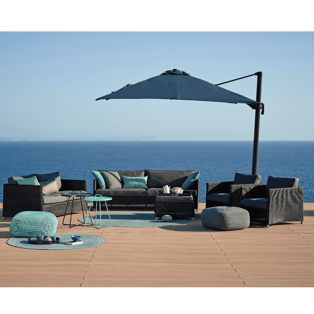 Boxhill's Diamond 3-Seater Weave Sofa lifestyle image with other Diamond Sofa collection and a parasol on wooden platform at seafront