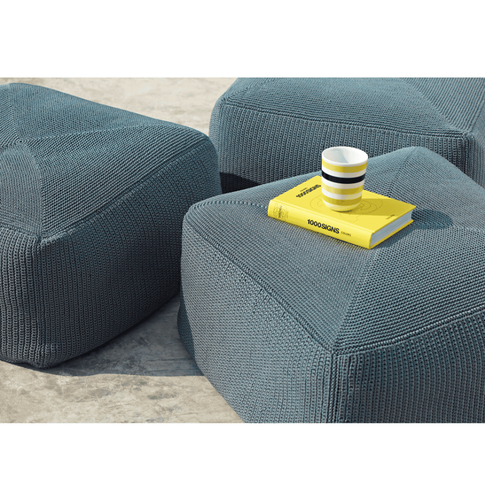 Boxhill's Divine Fabric Outdoor Footstool lifestyle image with small yellow book and a cup on top of it