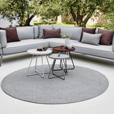 Boxhill's Dot Circle Rug lifestyle image with 3 round tables on it and sectional sofa at patio