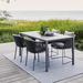 Boxhill's Dot Rectangle Rug with dining chairs and dining table on wooden platform beside grassy field near lake shore