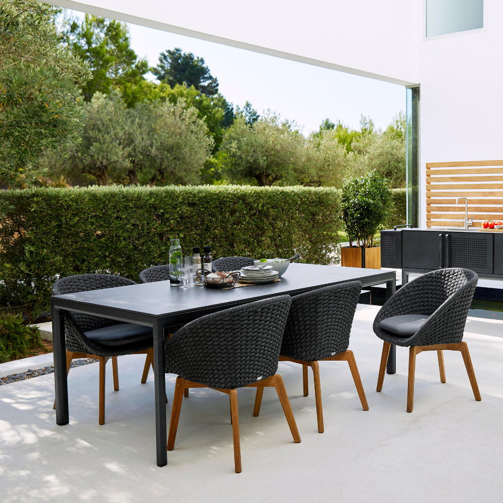 Boxhill's Drop Outdoor Dining Table Lava Grey lifestyle image with dining chairs at patio